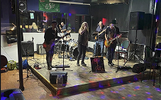 A full body shot of 4 members of a local band